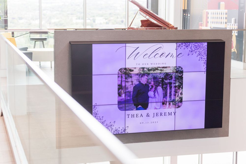 Multiple digital screens mounted on white walls displaying wedding-themed content.