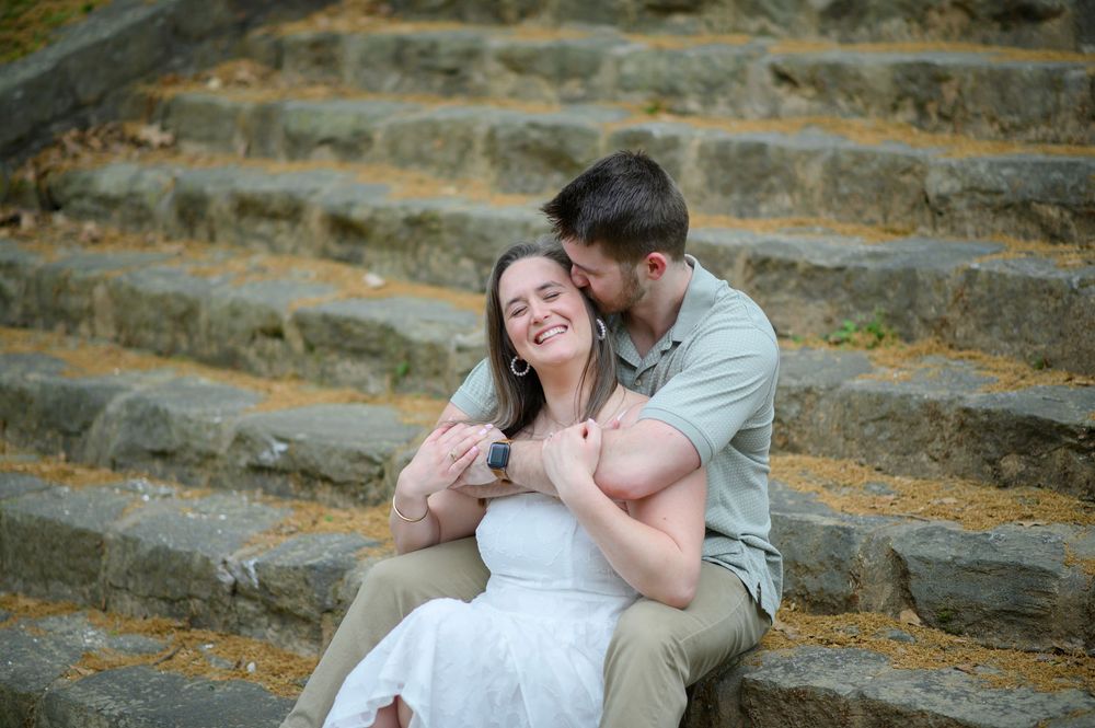 A couple poses on stone steps in an outdoor romantic engagement photoshoot sequence.