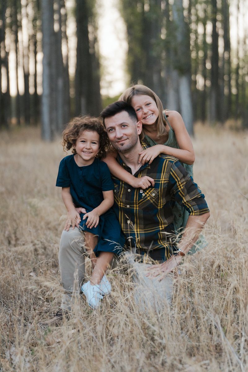 A family group poses together in a grassy field in Sydney at golden hour, showing three sequential playful moments during Family photoshoot