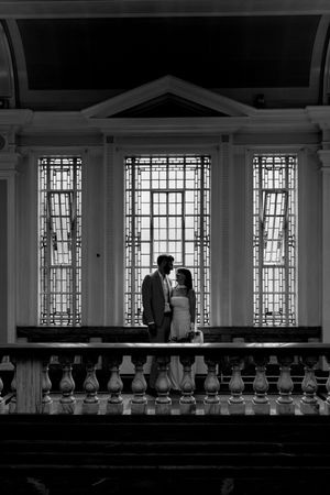 Silhouettes against a window in an elegant interior space with geometric patterns and architectural details.