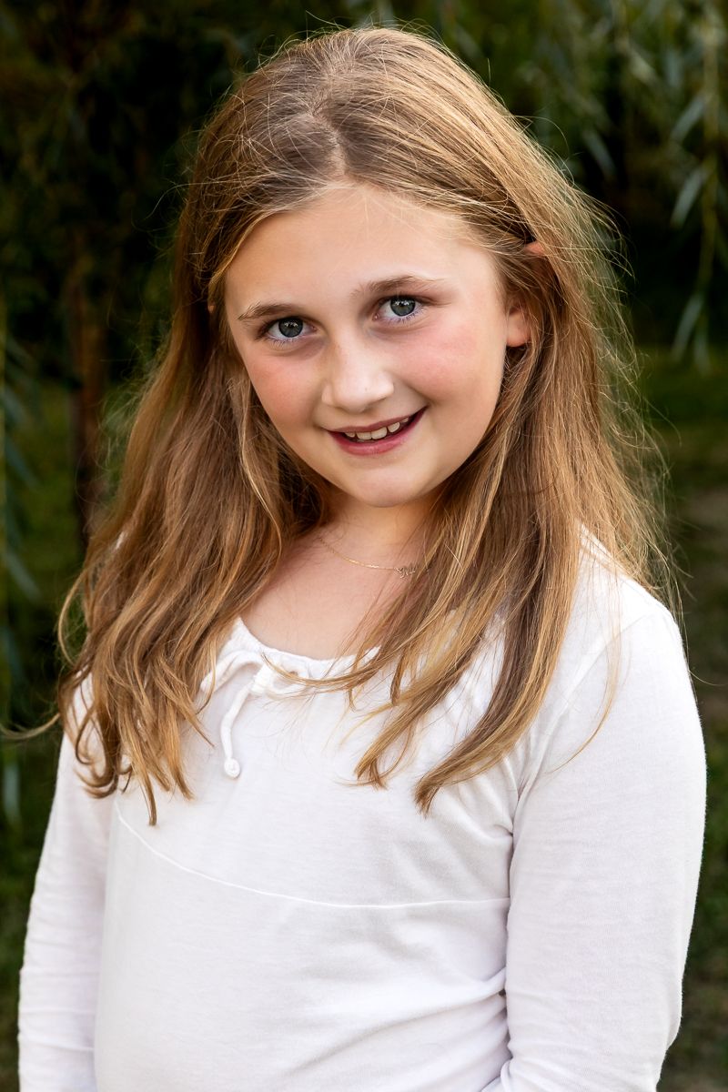 A series of five headshots showing a young subject in a white shirt expressing different playful expressions and poses.