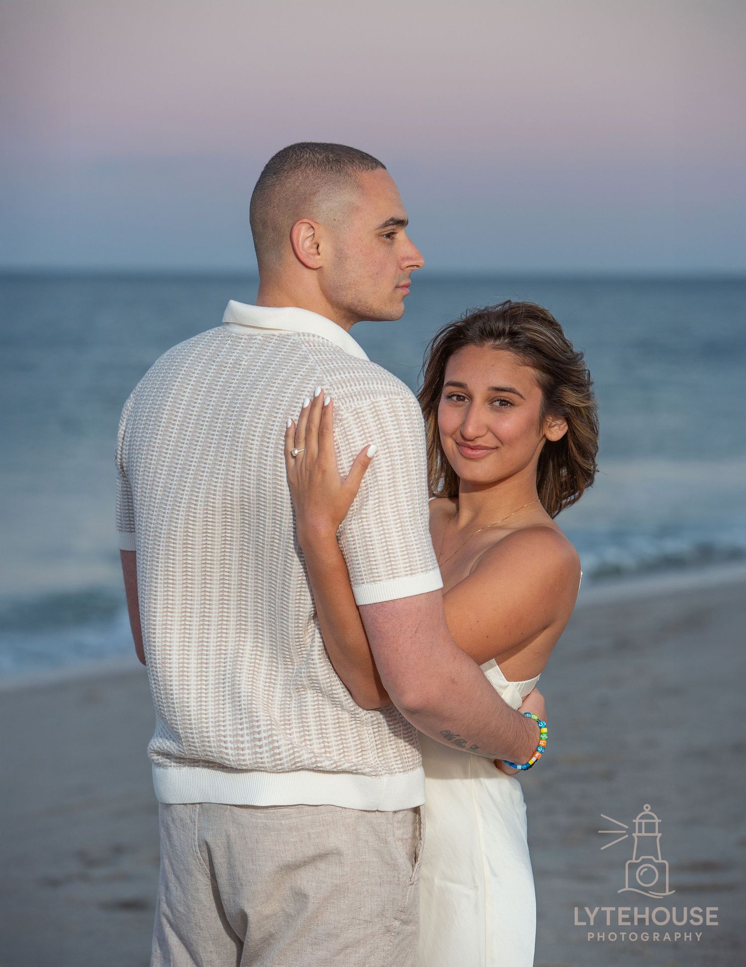 A romantic beach portrait shows a couple embracing at sunset, silhouetted against the tranquil ocean backdrop.