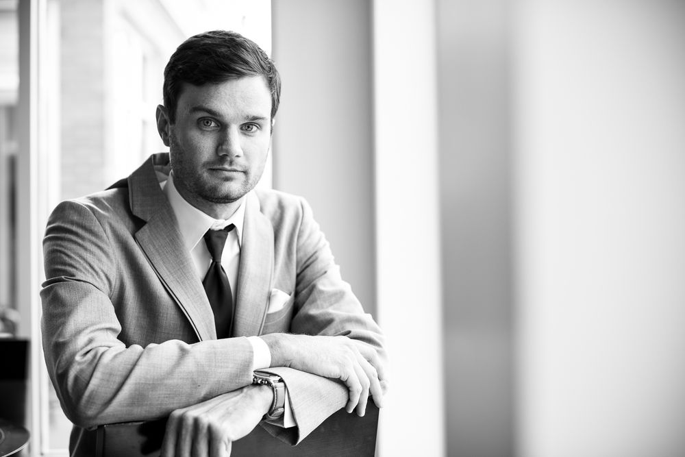 Professional black and white portraits show elegant poses by a window creating a sophisticated series.