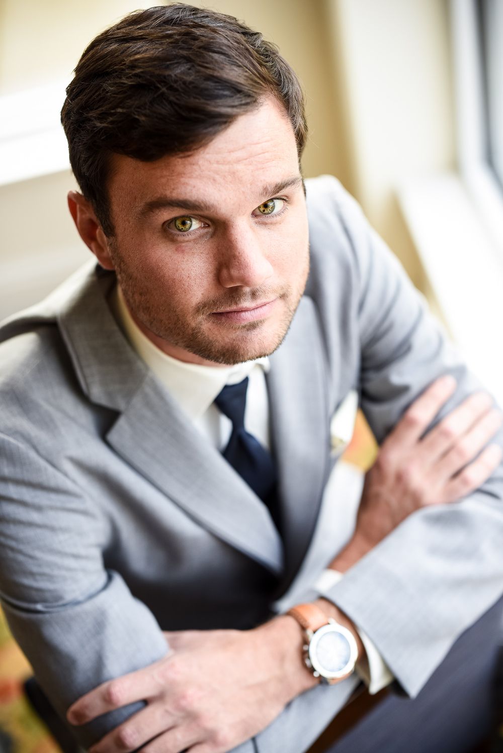Portrait series showing a man in a grey suit and tie looking at the camera from different angles.
