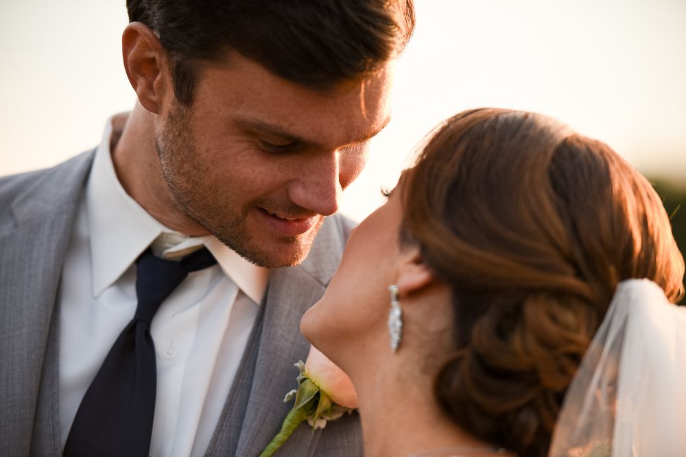 Romantic wedding couple sharing an intimate moment amid soft warm lighting.