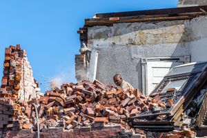Man shovels bricks disaster photograph