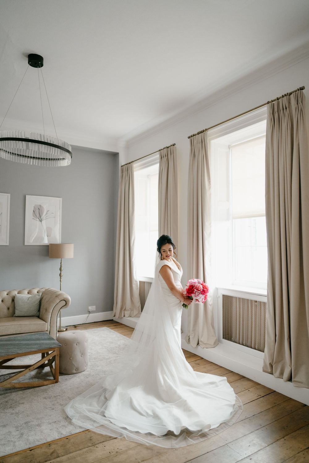 Elegant bridal gown displayed in a bright minimalist room with natural light.