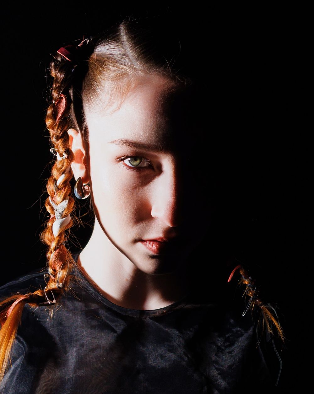 A person with braided hair emerges from shadow in a dramatic sequence of black and white portraits.