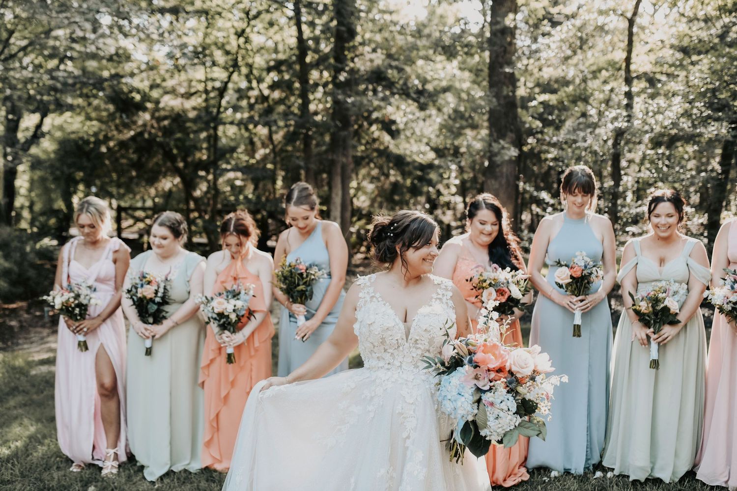 Bridal party laughing together in the grove at Whispering Oaks