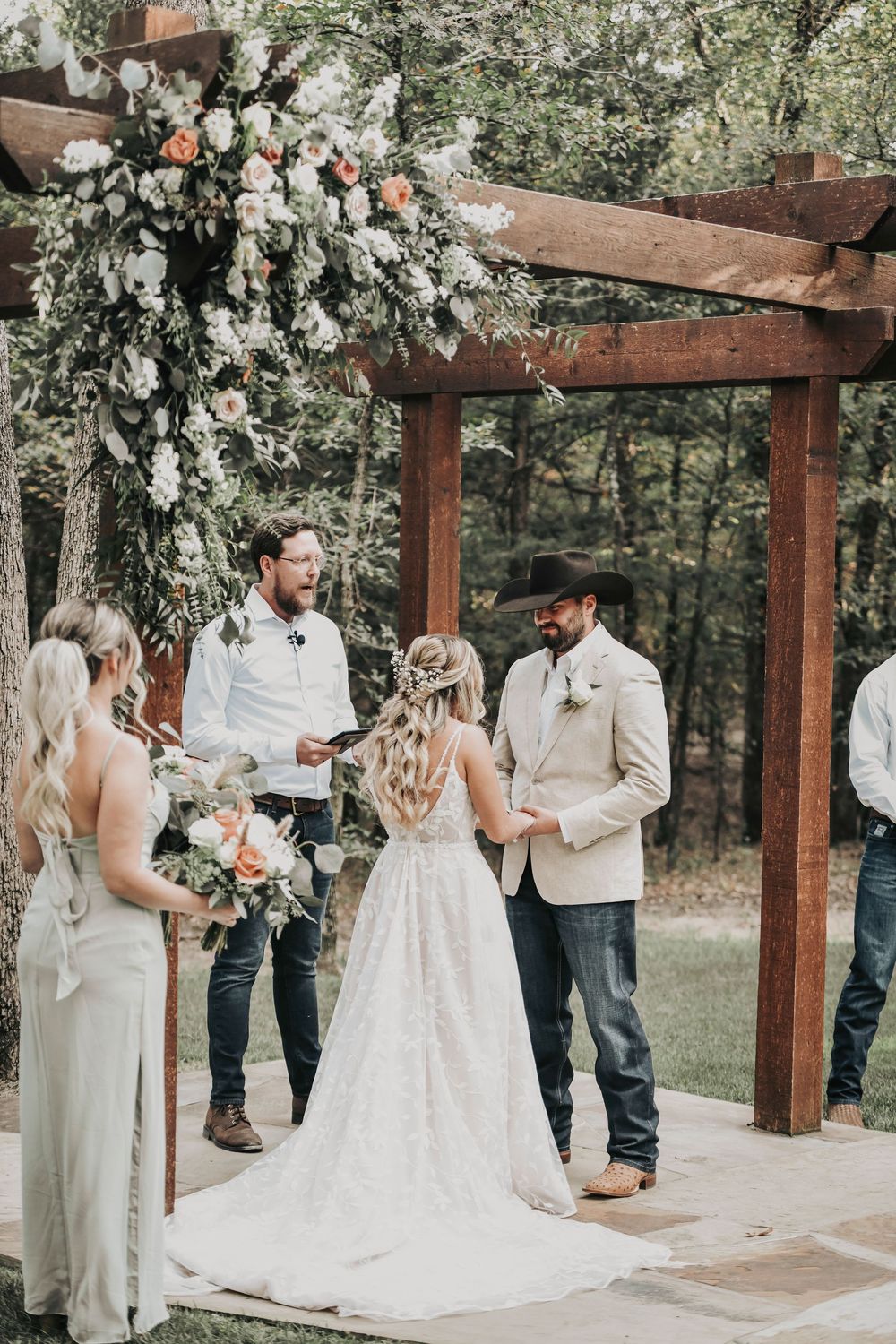 Couple exchanging rings beneath oak branches at Whispering Oaks