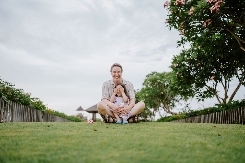 A family enjoys quality time together on a grassy hilltop with ocean views.
