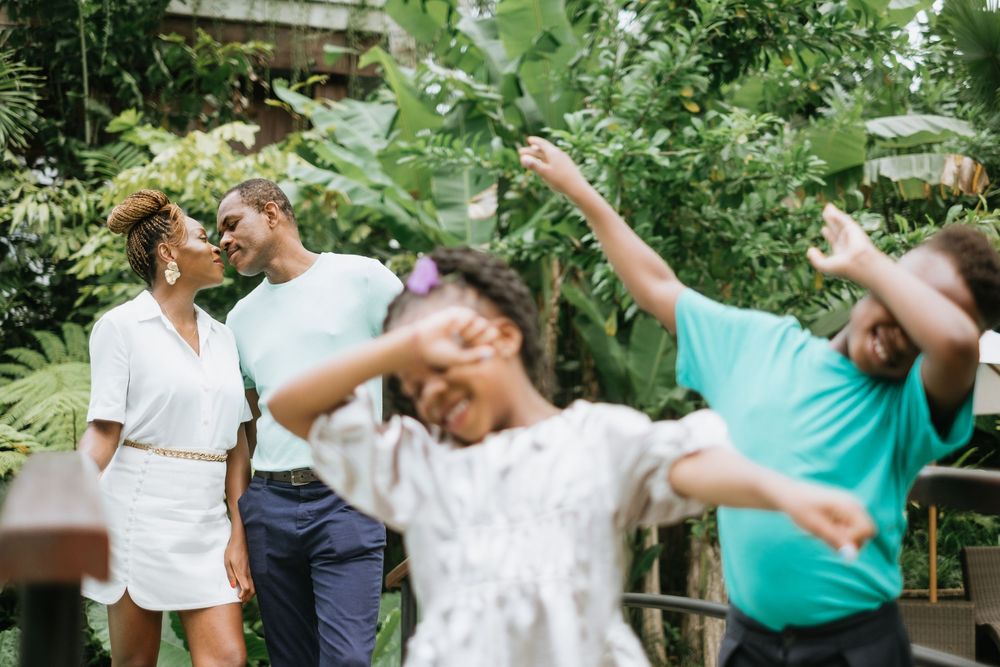 A playful family moment captured in a lush tropical garden setting.