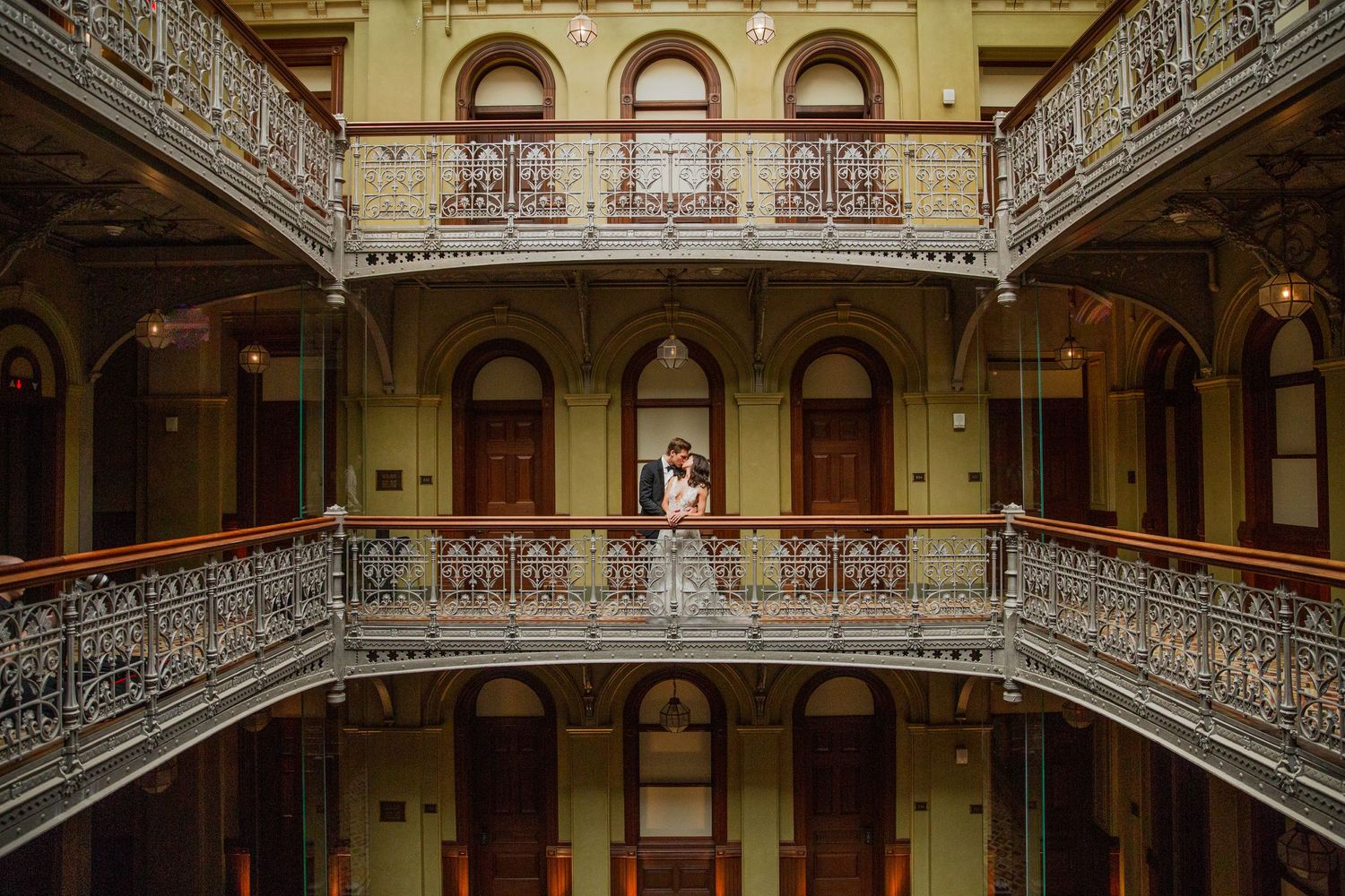 Elegant Victorian-style interior with ornate wrought iron balconies and arched doorways in a historic building.