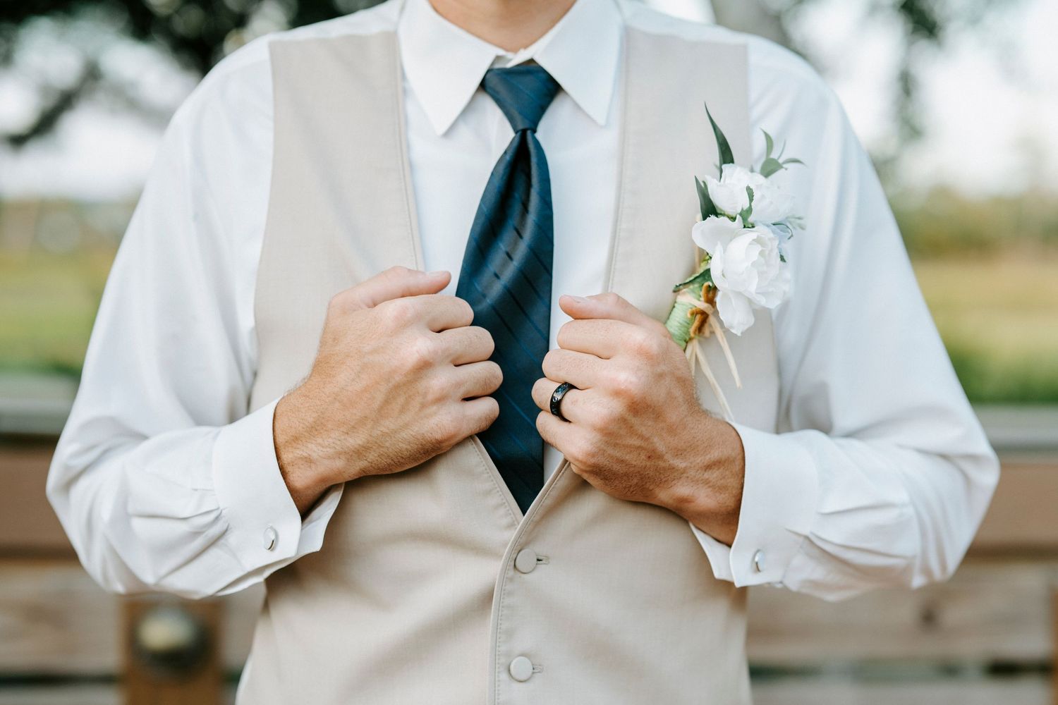 A collage of formal wedding attire details showing navy blue tie adjustments and white boutonniere on a dress shirt.
