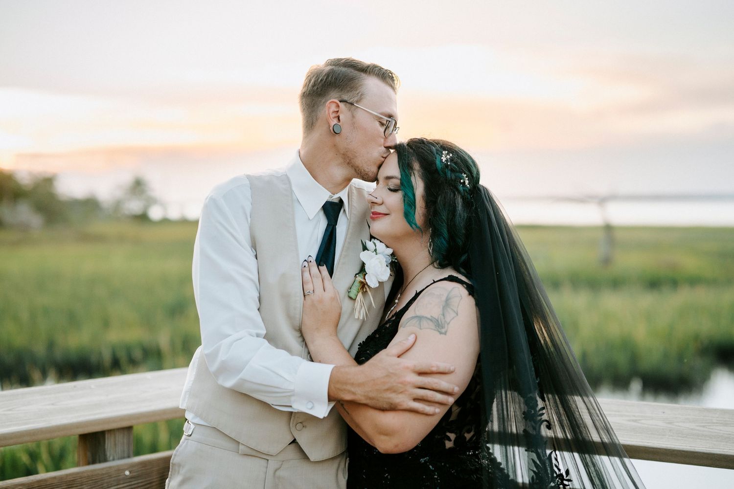 Couple shares romantic moments near coastal marshland at sunset in a dreamy photo set.