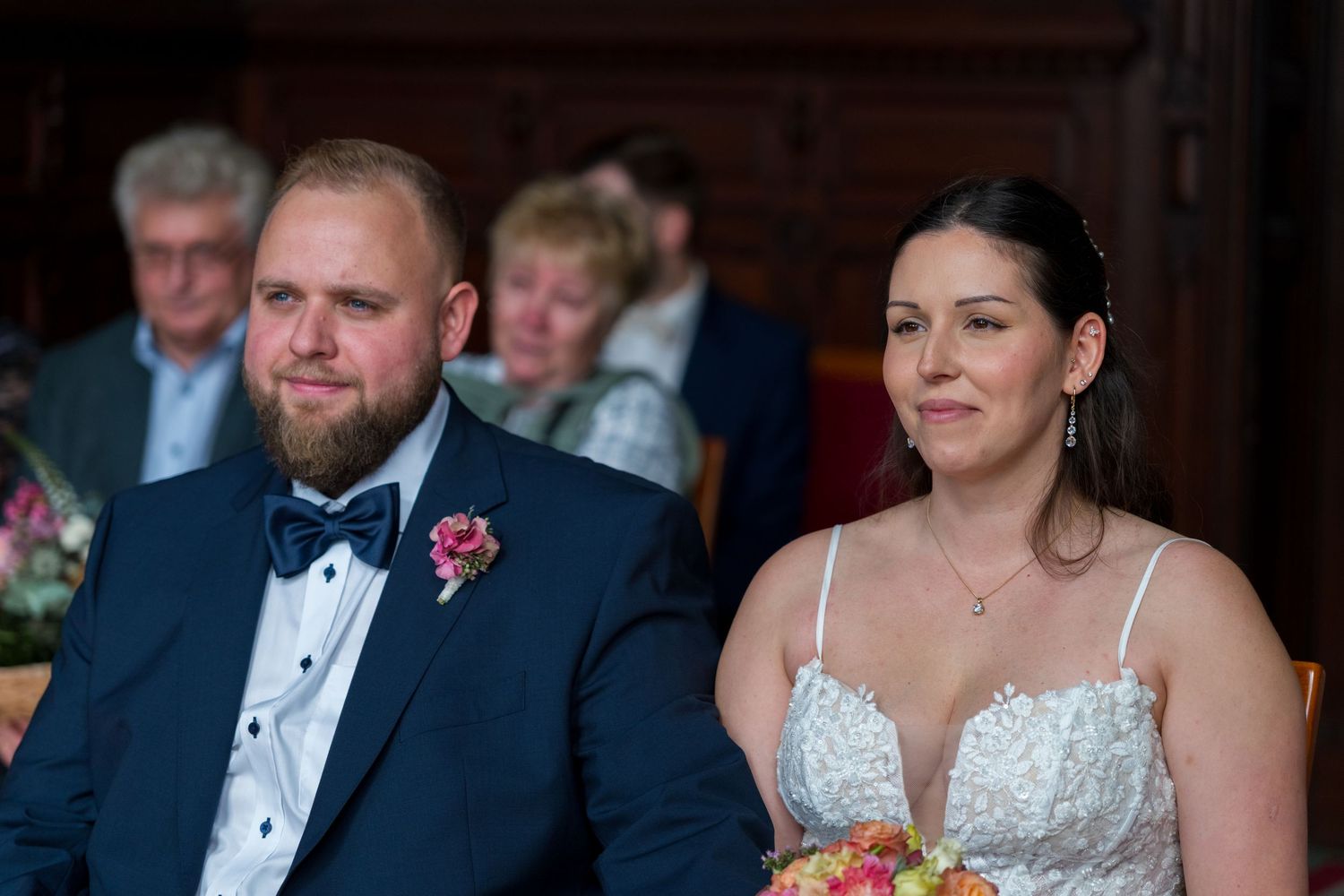 Brautpaar sitzt während der standesamtlichen Trauung in Neukölln und lächelt sich an, Hochzeitsfotograf Berlin