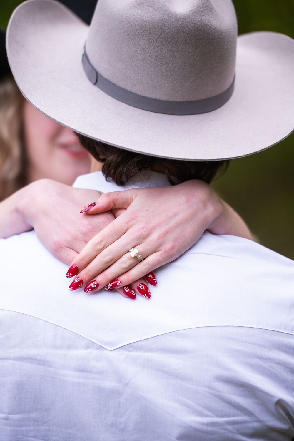Woman wearing white dress and gray felt hat showing engagement ring in sequence of romantic detail shots.