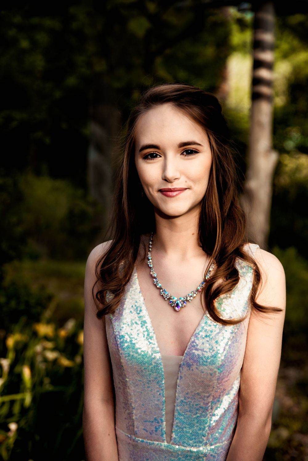 Teen models her prom dress and jewelry in warm light