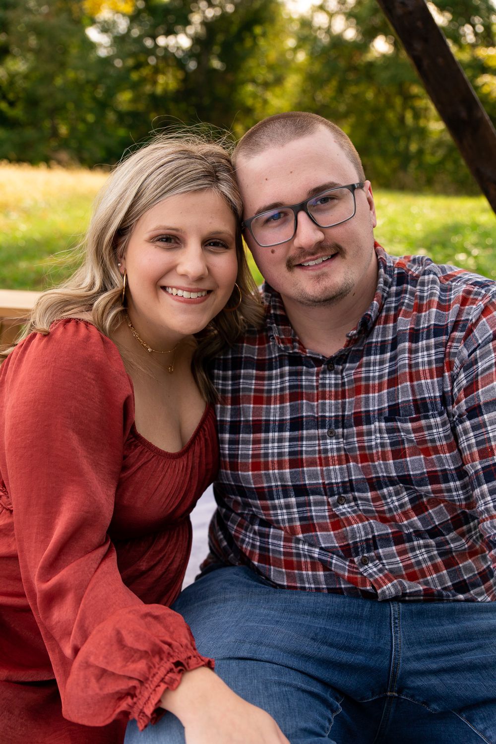 Couple sharing intimate moment while sitting outdoors in casual attire.
