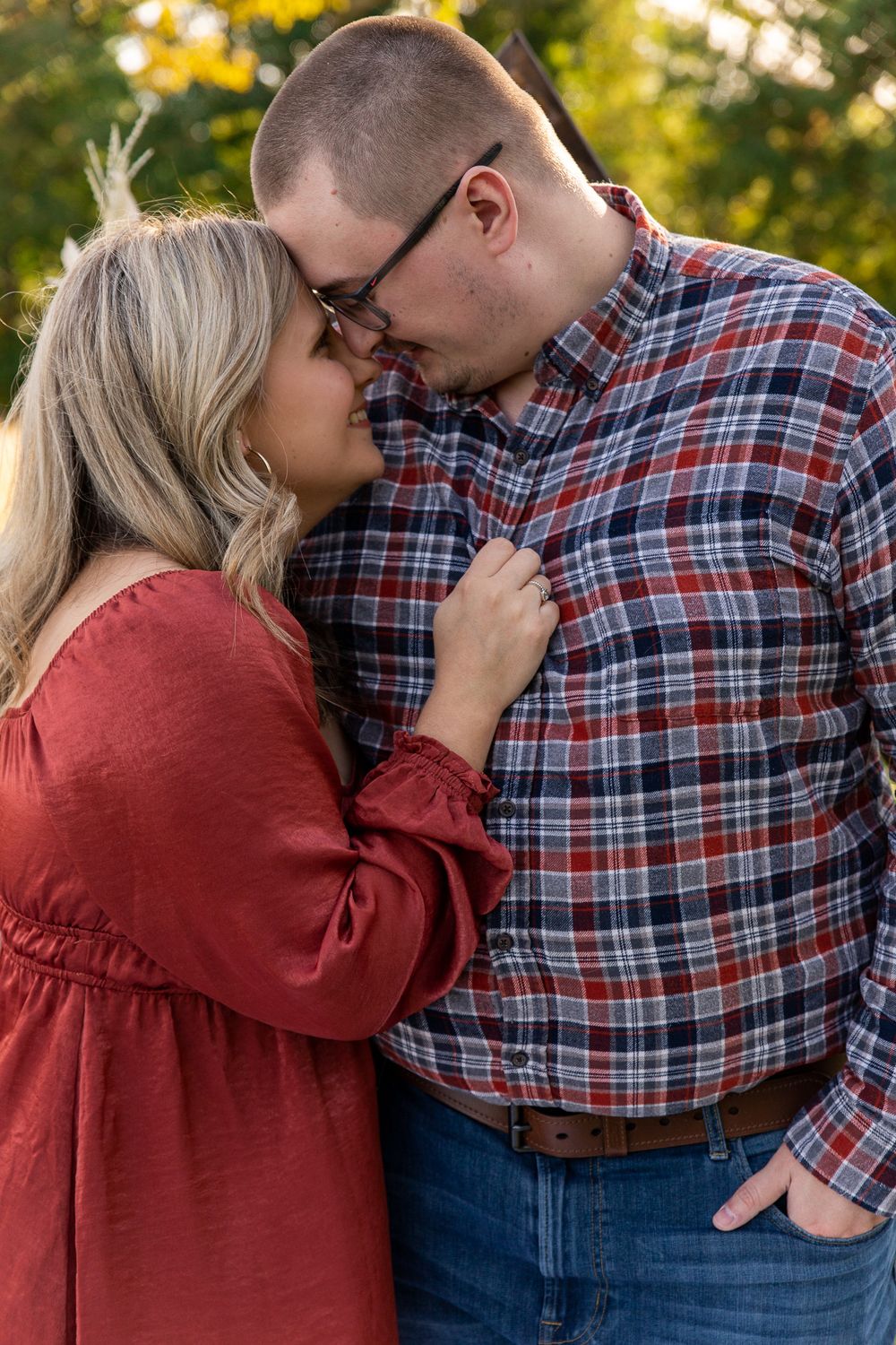 Romantic couple in casual wear sharing tender moments during outdoor photoshoot.