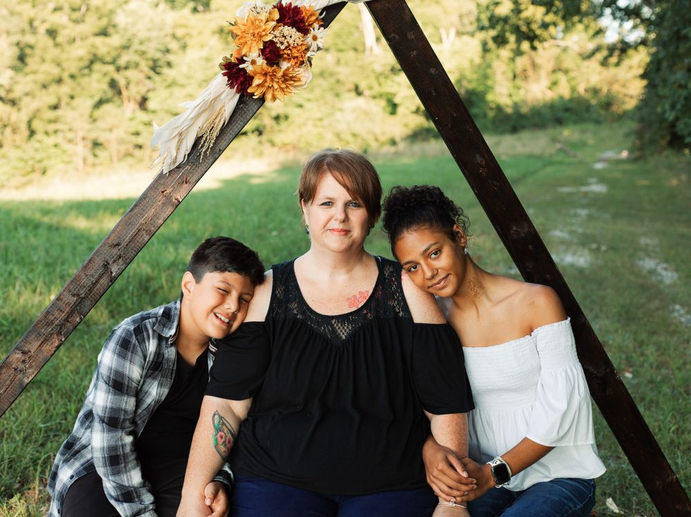 Group photo session under wooden frame structure in outdoor setting.