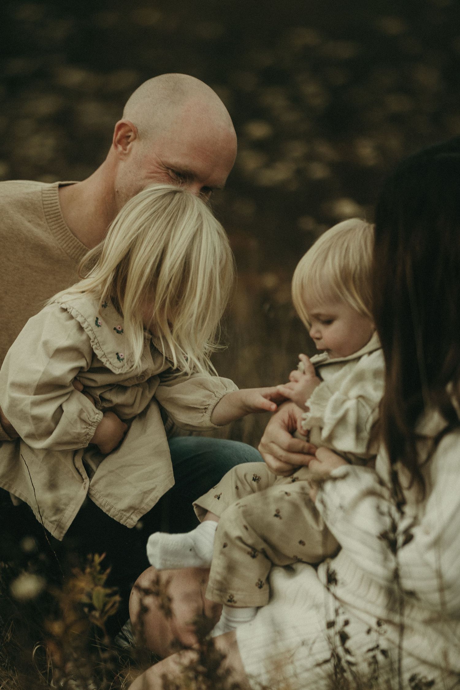 A tender family moment captured in warm autumn tones outdoors.