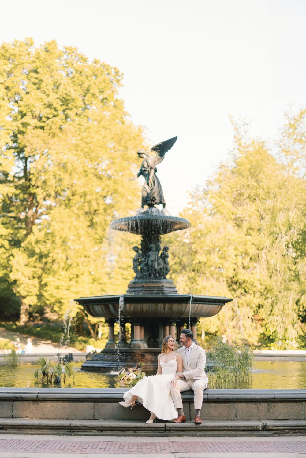 Bride and groom sitting together at Bethesda Fountain in Central Park, NYC.