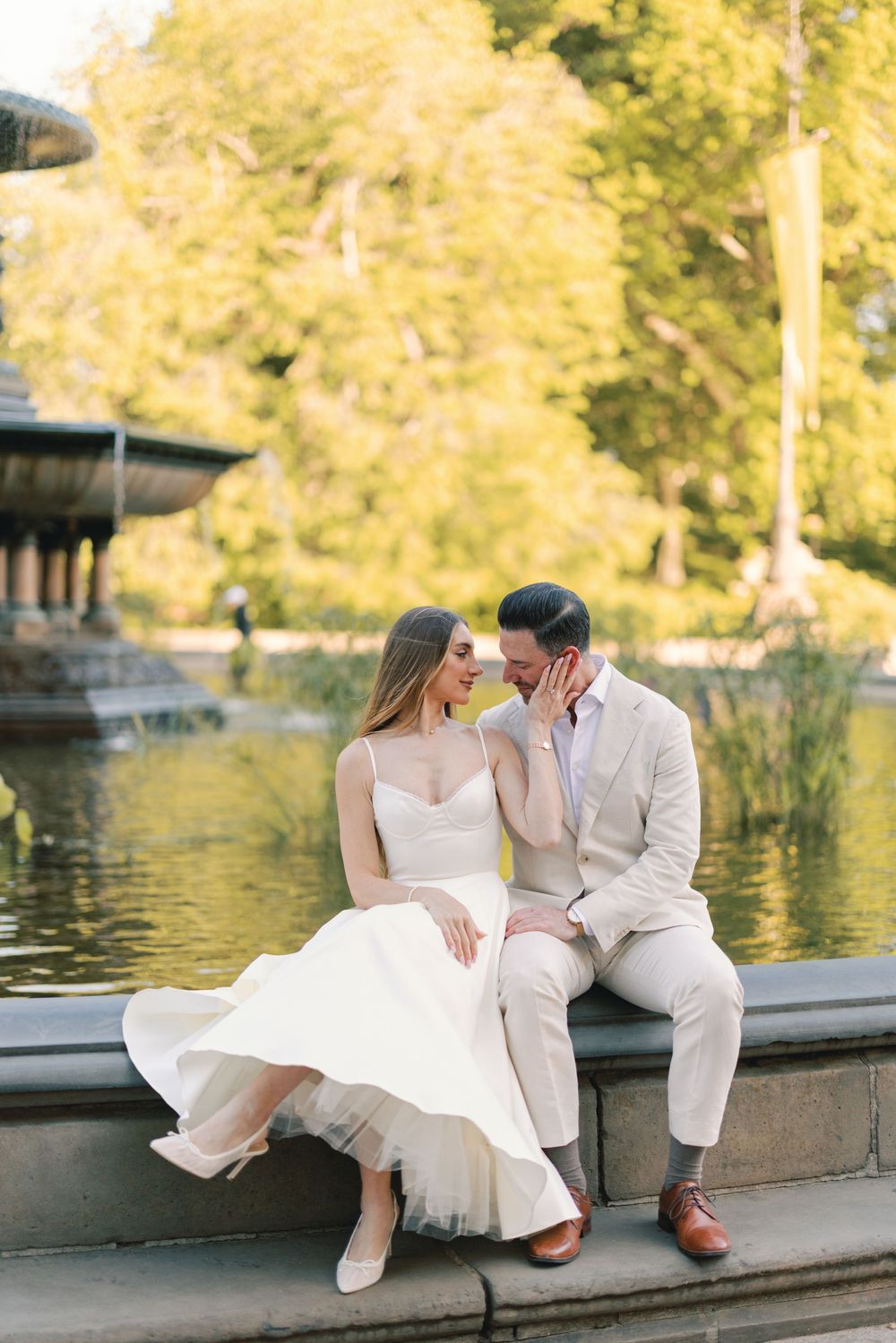 Wedding couple sitting intimately by Bethesda Fountain in Central Park, NYC.
