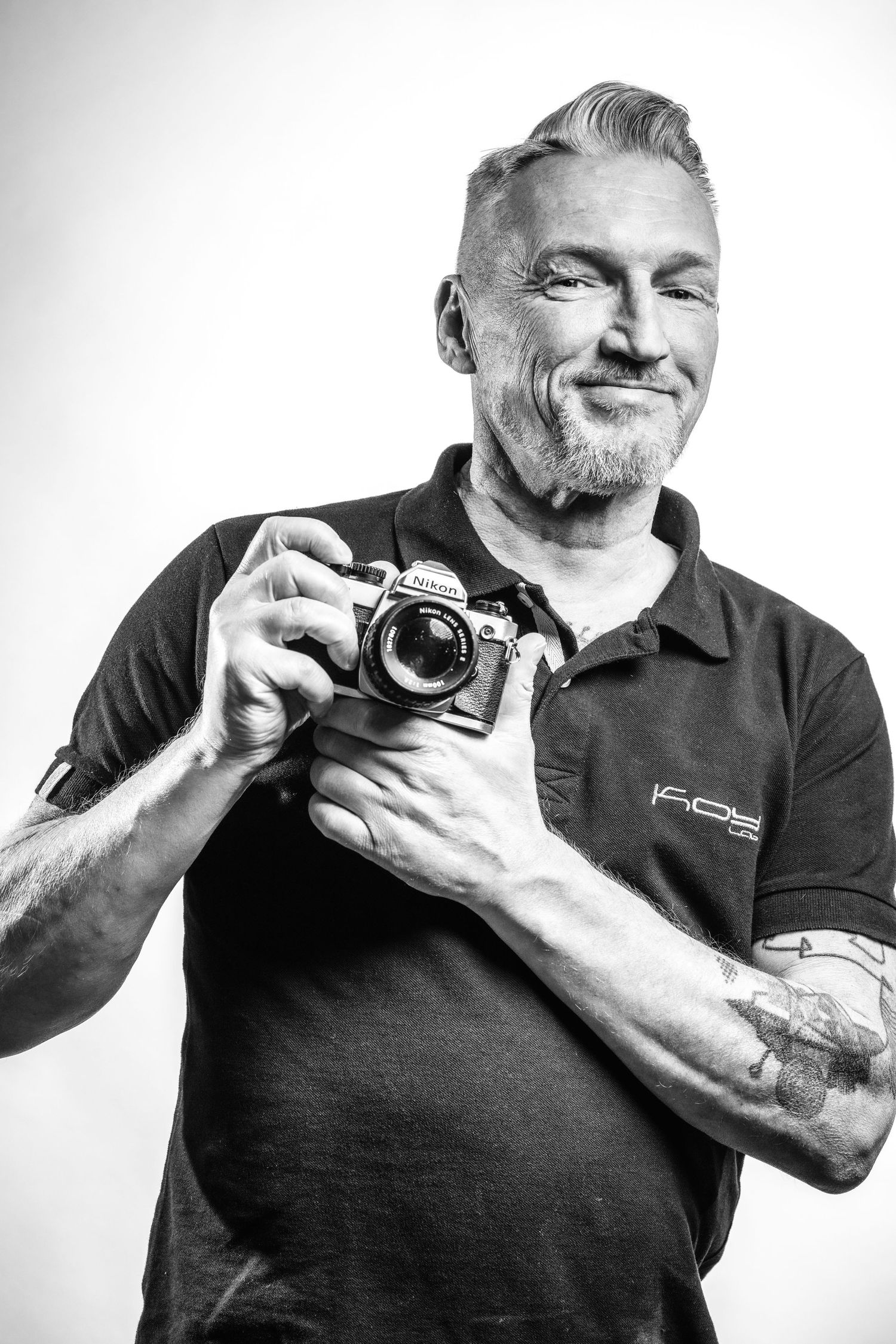 Zelfportret van fotograaf Bart Boodts met Nikon camera, professioneel zwart wit portret voor personal branding en LinkedIn profielfoto.