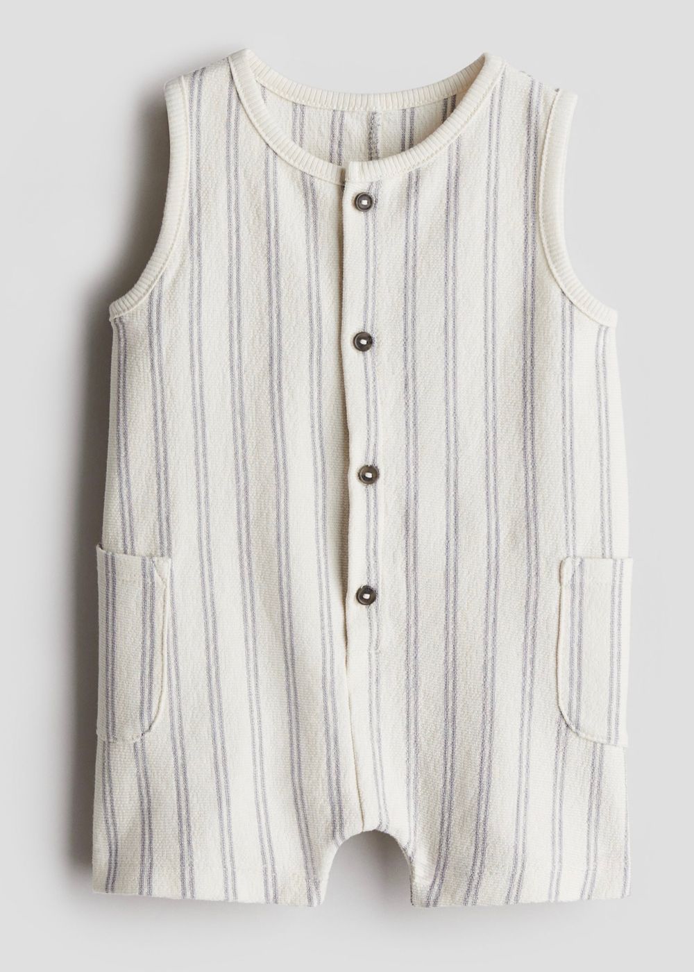 White and blue striped sleeveless baby romper with button front and front pockets.