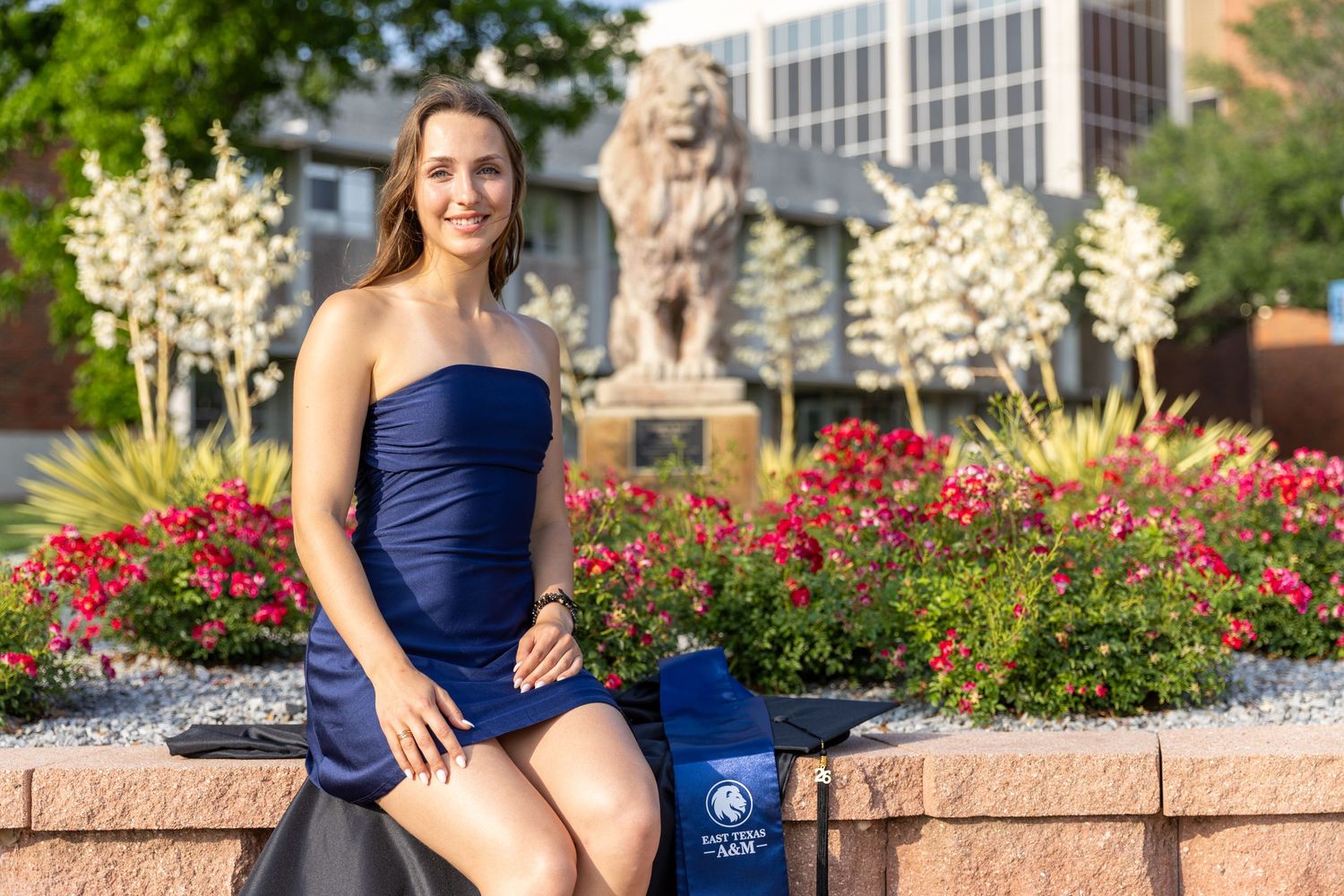portraits in front of the lion and flowers by the library on campus at East Texas A&M University