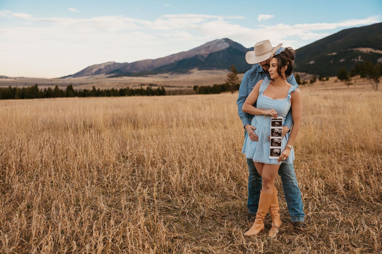 Cowboy and wife shows off ultrasound photos in the mountains of Red Lodge, Montana captured by Montana Photographer Sabrina Maire