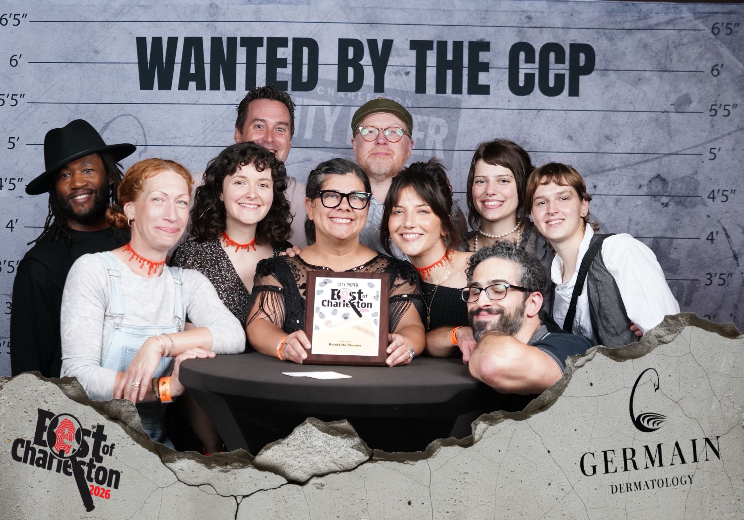 Group of people posing at Best of Charleston award event with Wanted by the CCP backdrop and Germain Dermatology sponsor.