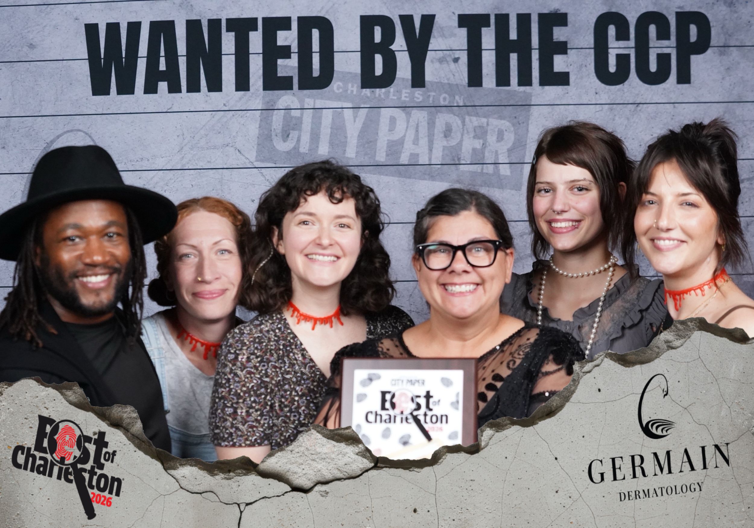 Six people pose at a Best of Charleston City Paper awards event under a Wanted by the CCP banner.