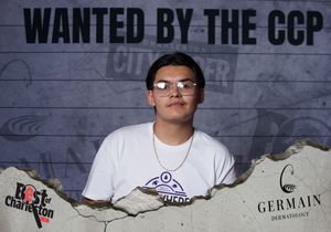 Young man in white t-shirt posing solo at Wanted by the CCP Best of Charleston photo booth.
