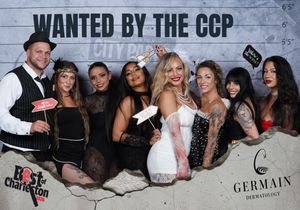 Group of eight people posing at a Wanted by the CCP Best of Charleston photo booth event.