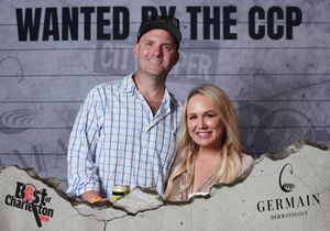 Couple smiles together at Best of Charleston Wanted by the CCP sponsored event backdrop.