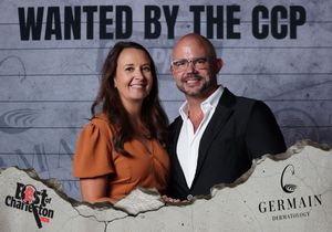 Man and woman posing together at the Wanted by the CCP Best of Charleston photo booth.