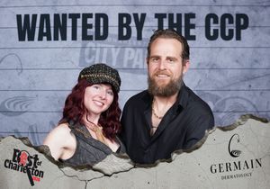 Man and woman pose together at Best of Charleston City Paper CCP wanted poster photo booth.