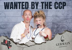 Two people posing playfully at Best of Charleston Wanted by the CCP themed photo booth event.