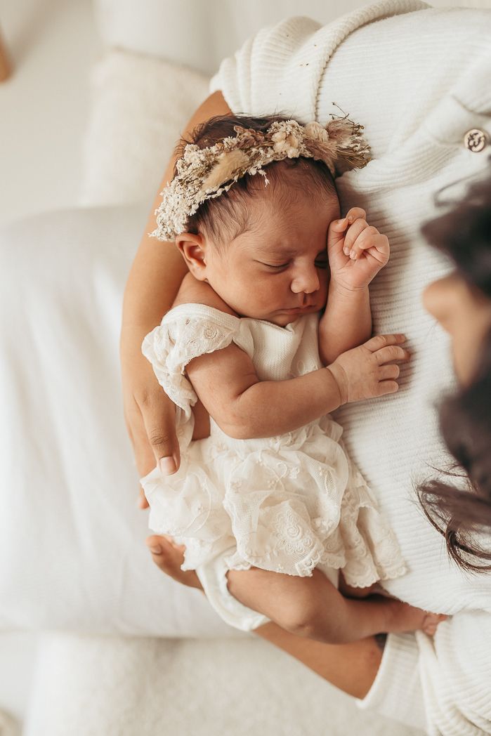 Recién nacida en brazos de su madre durante una sesión de fotografía newborn en el estudio de María Guerrero.