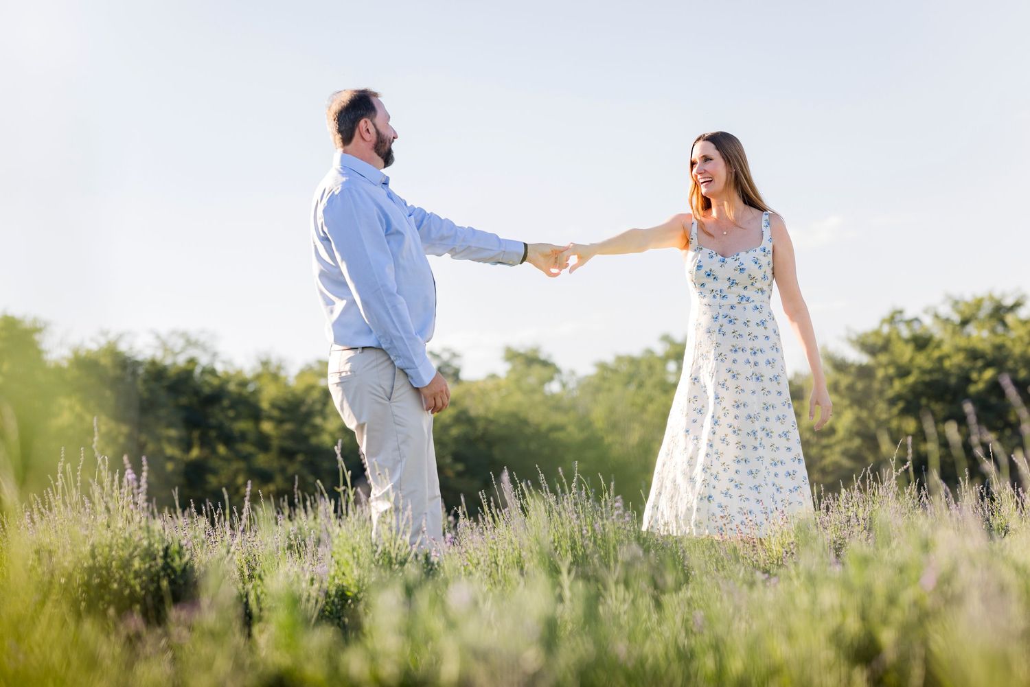 A couple shares their first dance in a rustic barn venue illuminated by overhead string lights. Iowa City wedding photographer.