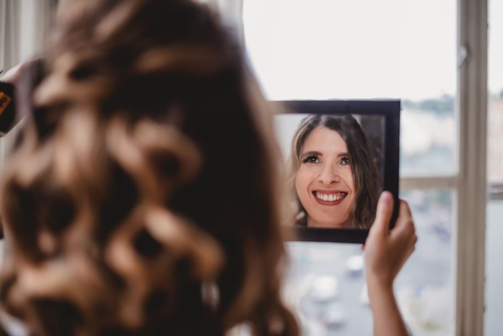Bridal preparations by a bright window with natural light streaming in.