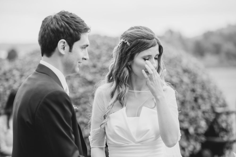 Wedding couple shares candid black and white moments during their outdoor celebration.