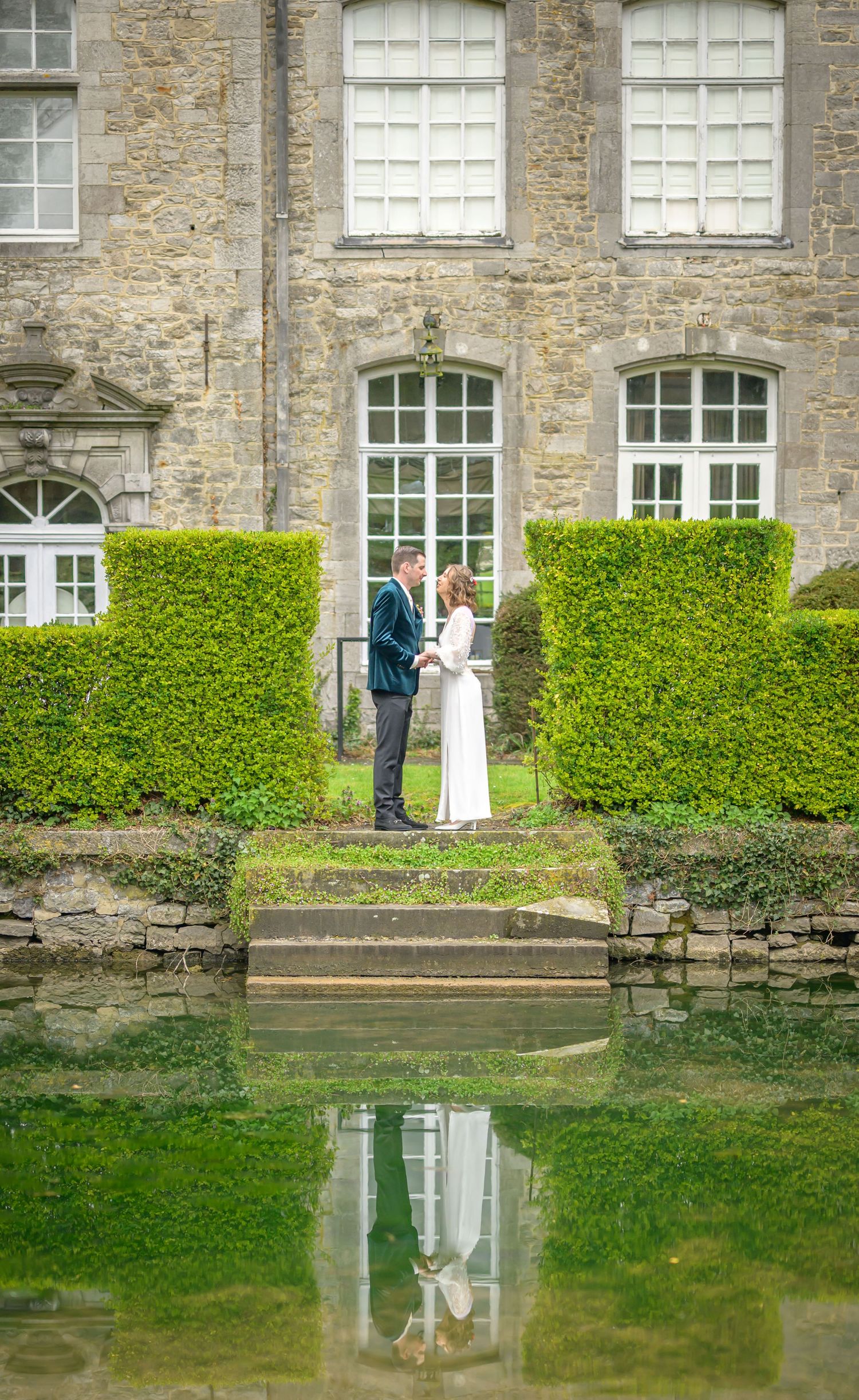 A romantic wedding couple poses in a series of elegant shots under stone archways at a historic European castle.