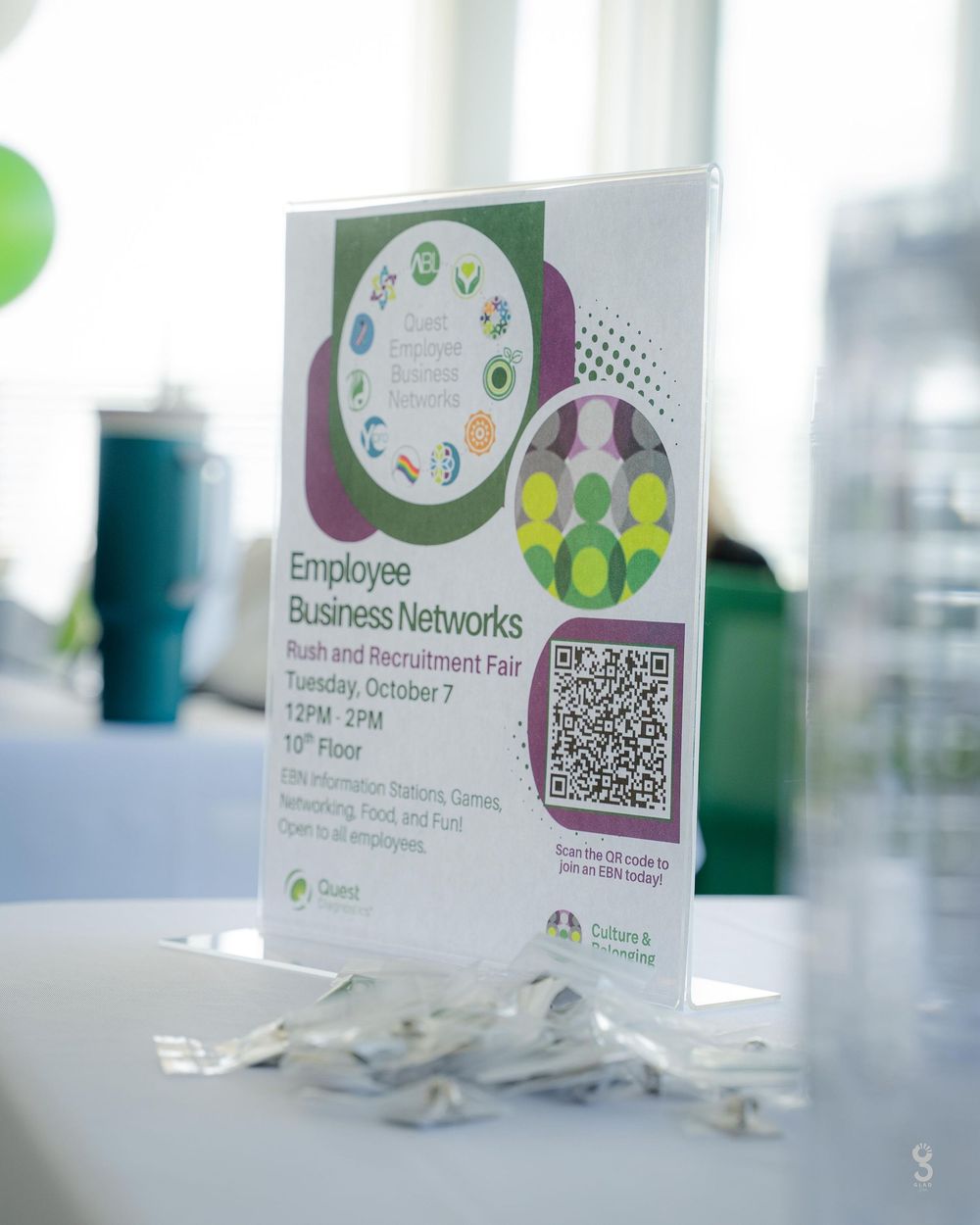 Business networking event displays with QR codes and employee information cards arranged on a table.
