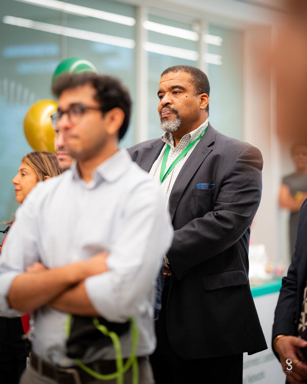 Business professionals gathered in a brightly lit office space for a meeting or presentation.
