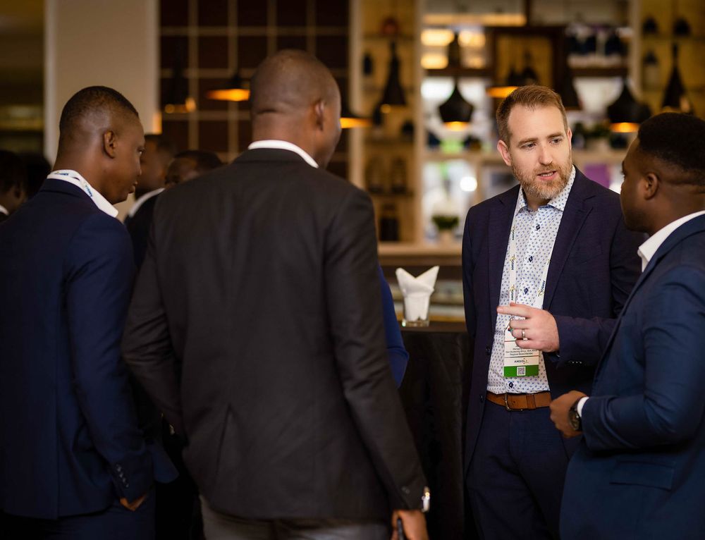 Businesspeople networking and socializing at an elegant bar or restaurant venue during a professional event.