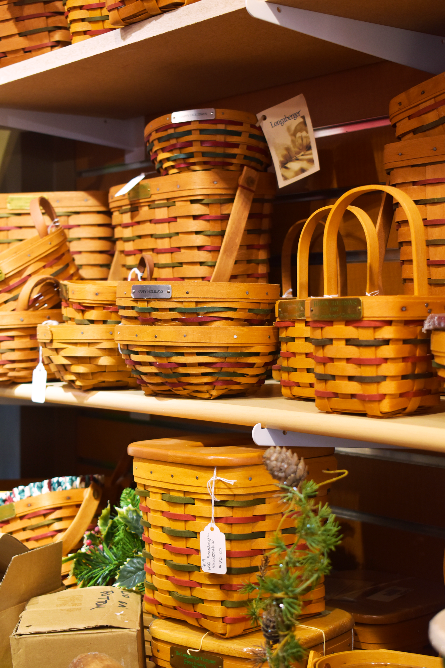 Display of vintage Longaberger woven baskets stacked on wooden shelves.