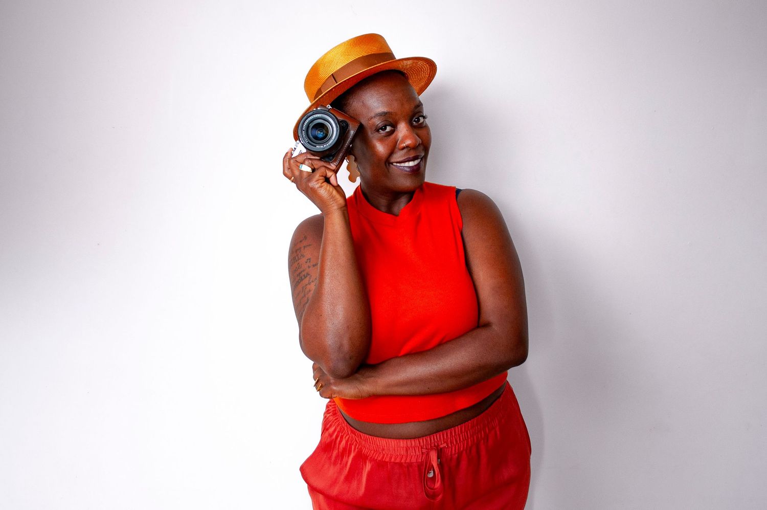 photographe noire pose avec une caméra devant son visage